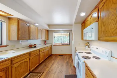 a kitchen with wooden cabinets and a white stove top oven at Owl's Lookout (05/061) in Groveland
