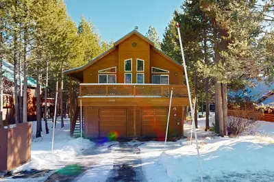 a wooden house with a garage in the snow at Jade House in Truckee