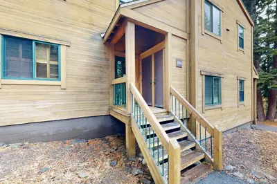 a wooden house with a staircase leading to the front door at Gold Bend 5034 in Truckee
