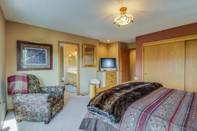 a bedroom with a bed and a chair and a tv at Hillside View Vacation Home in Truckee