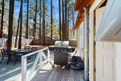 a grill on a deck next to a house at Cozy Bobby Grey Manor in South Lake Tahoe
