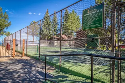 a fence with a tennis court with a sign on it at Tahoe Keys Waterfront with Dock in South Lake Tahoe