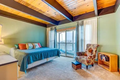 a bedroom with a bed and a chair and a window at Tahoe Keys Waterfront with Dock in South Lake Tahoe