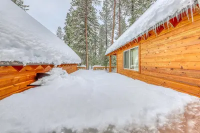 a log cabin covered in snow in the woods at Snowpeak Chalet in Tahoe Donner in Truckee