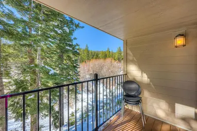 a room with a balcony with a chair and a large window at Carnelian Woods Sanctuary in Carnelian Bay