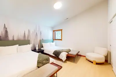 a large bedroom with two beds and a chair at Sierra Solstice in Truckee