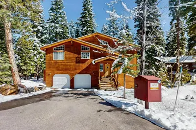 a log home in the snow with a driveway at Fawn Lodge in Tahoe Vista
