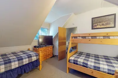 a bedroom with two bunk beds and a tv at West Shore Lakeview Beauty* in Homewood