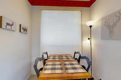 a table and chairs in a room with a window at Christy Lane Condo in Olympic Valley