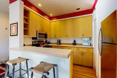 a kitchen with wooden cabinets and a refrigerator at Christy Lane Condo in Olympic Valley