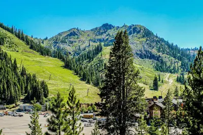 a view of a mountain with trees and a town at Christy Lane Condo in Olympic Valley