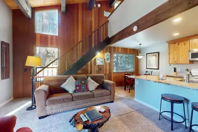 a living room with a couch and a staircase at Nordic Retreat in Kings Beach