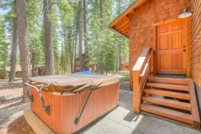 a wooden cabin with a porch and a wooden door at Beaver Pond Northstar Luxury Chalet with Hot Tub in Truckee