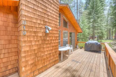 a wooden deck with a bench on the side of a house at Beaver Pond Northstar Luxury Chalet with Hot Tub in Truckee