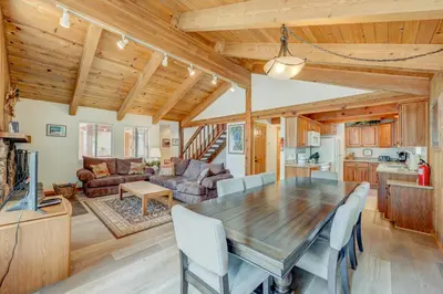 a kitchen and living room with a wooden table and chairs at Beaver Pond Northstar Luxury Chalet with Hot Tub in Truckee