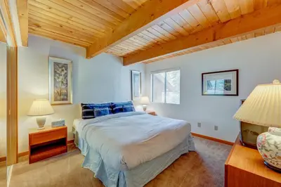 a bedroom with a large bed and a wooden ceiling at Beaver Pond Northstar Luxury Chalet with Hot Tub in Truckee