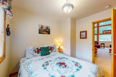 a bedroom with a bed with a blue and white comforter at Snowpeak Tahoe Donner Golf Course Views in Truckee