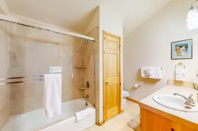 a bathroom with a tub and a sink and a toilet at Snowpeak Tahoe Donner Golf Course Views in Truckee