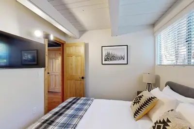 a bedroom with a bed and a window at Canterbury Kings Beach Treehouse in Kings Beach