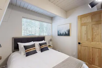 a bedroom with a large white bed and a window at Canterbury Kings Beach Treehouse in Kings Beach