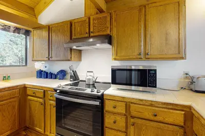 a kitchen with wooden cabinets and a stove top oven at View Condo at Northstar in Truckee