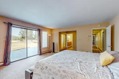 a bedroom with a large bed and a large window at Back Nine Bungalow in South Lake Tahoe
