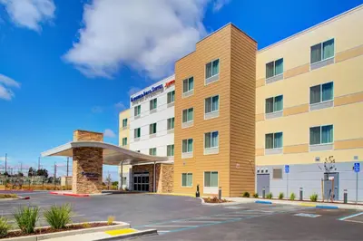 an exterior view of a hotel with a parking lot at Fairfield Inn & Suites by Marriott Hollister in Hollister