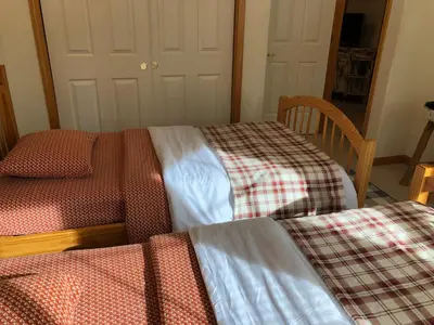 a room with three beds and a table and a chair at Kingswood Estate Cabin Retreat in Kings Beach