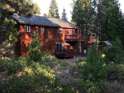 a large wooden barn with a deck in the woods at Kingswood Estate Cabin Retreat in Kings Beach