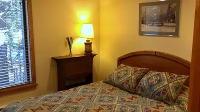 a bedroom with a bed and a lamp and a window at 114 Premium Condo in Mammoth Lakes