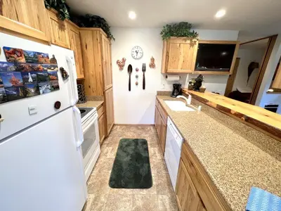 a kitchen with wooden cabinets and a white refrigerator at 141 Premium Condo in Mammoth Lakes