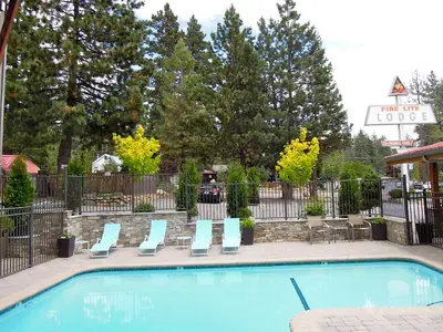 a swimming pool with lounge chairs next to a fence at Firelite Lodge in Tahoe Vista
