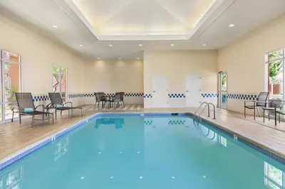 a large swimming pool with chairs and tables in a room at Fairfield Inn & Suites by Marriott Reno Sparks in Sparks
