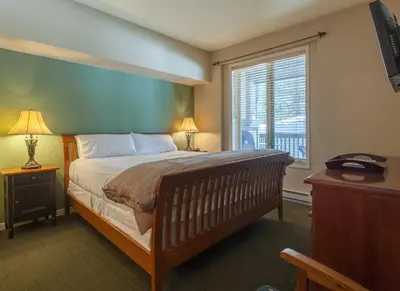 a bedroom with a large bed and a window at Mammoth Green # 105 in Mammoth Lakes