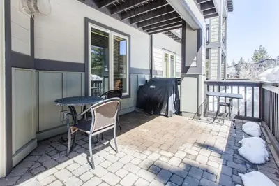 a patio with a table and chairs on a balcony at Mammoth Green # 105 in Mammoth Lakes