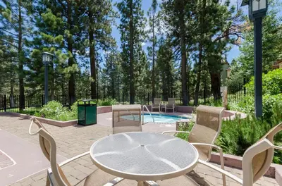 a patio with a table and chairs and a pool at Mammoth Green # 105 in Mammoth Lakes