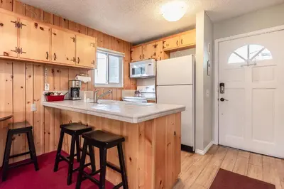 a kitchen with wooden cabinets and a white refrigerator at Mammoth View Villas # 34 in Mammoth Lakes