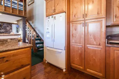 a kitchen with a white refrigerator and wooden cabinets at Snowcreek # 320 - Phase II in Mammoth Lakes