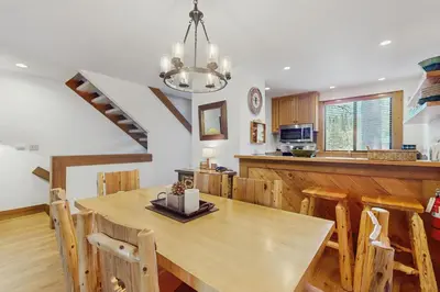 a kitchen and dining room with a table and a staircase at Silver Strike at Northstar in Kingswood Estates