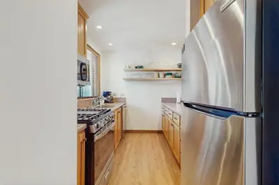 a kitchen with a stainless steel refrigerator and wooden cabinets at Silver Strike at Northstar in Kingswood Estates