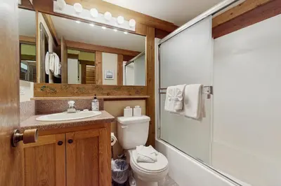 a bathroom with a toilet and a sink and a mirror at Silver Strike at Northstar in Kingswood Estates