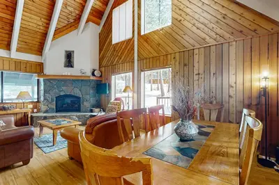 a living room with a table and a fireplace at The Hideaway in Meadow Lake Park