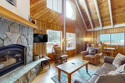 a living room with a stone fireplace in a house at The Hideaway in Meadow Lake Park