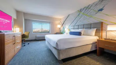 a hotel room with a large bed and a television at Circus Circus Reno, A Caesars Destination in Reno