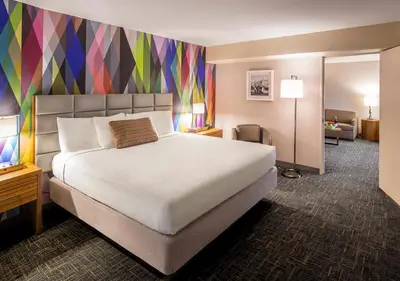 a bedroom with a large bed with a colorful wall at Circus Circus Reno, A Caesars Destination in Reno