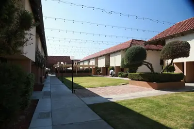 a walkway in front of a building with lights at Ramada by Wyndham Fresno North in Fresno