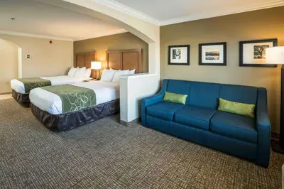 a hotel room with two beds and a couch at Comfort Suites Fresno River Park in Fresno
