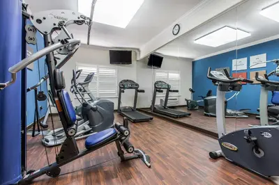 a gym with several treadmills and cardio machines at Comfort Suites Fresno River Park in Fresno