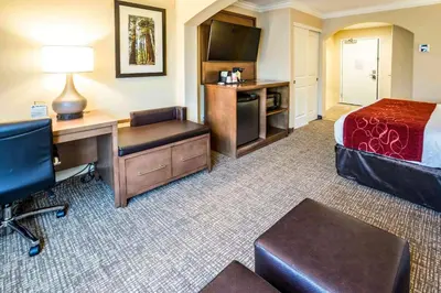 a hotel room with a desk and a bed and a desk sidx sidx sidx sidx at Comfort Suites Fresno River Park in Fresno