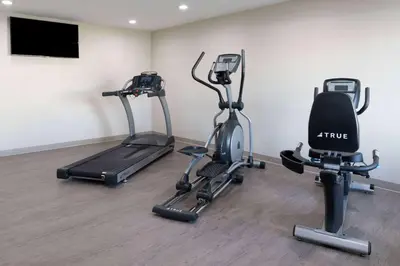 a gym with two exercise bikes and a flat screen tv at Ramada by Wyndham Modesto Yosemite Area in Modesto